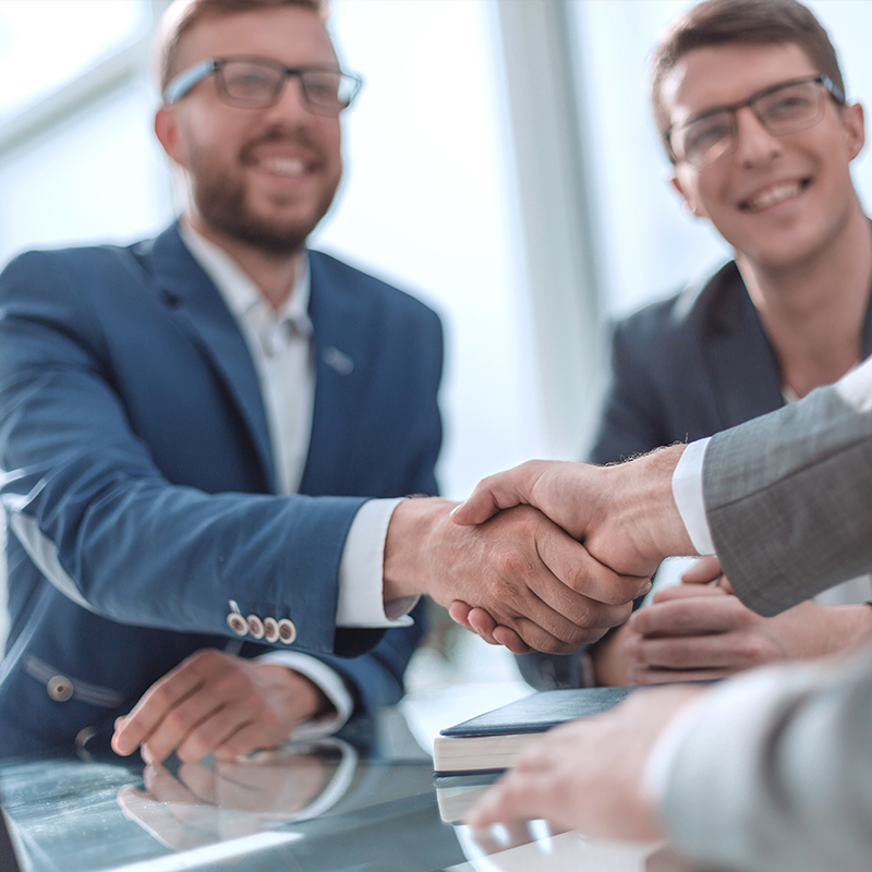 Close-up of two diverse hands firmly shaking, symbolizing the trusted partnership model of Plant Indy.
